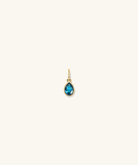 Gold earring featuring a blue gem, showcased as the Small Pear Pendant, adding elegance with its vibrant color and shine.