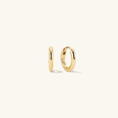 Tube Huggie Hoops: A pair of modern gold hoop earrings with a clicker closure for comfort and security, shown in close-up detail.
