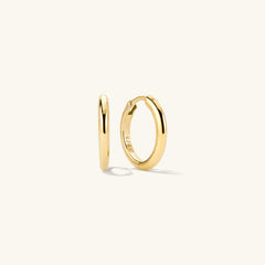 Tube Medium Hoops: A pair of gold hoop earrings with a modern tube design and a secure clicker closure for comfort.