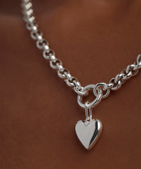 Close-up of a Puffy Heart Charm on a silver chain necklace, showcasing the detailed heart-shaped pendant.