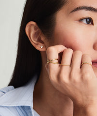 Close-up of a woman's hand wearing the Duo Ring, featuring two intertwining 14k solid gold bands that move effortlessly together.