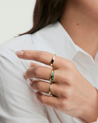 Hand wearing Baguette Emerald Half Eternity Band, featuring eight baguette emeralds set in 14k solid gold, highlighting its elegant design and unique gemstone inclusions.