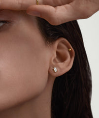 Close-up of a woman's ear wearing a Lab Grown Sapphire Emerald Cut Stud earring, showcasing the elegant and classic design.