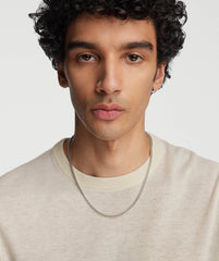 Man with curly hair wearing a white shirt and a handcrafted sterling silver 3.7mm Round Box Chain Necklace.