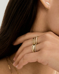 Close-up of a woman's hand showcasing the Slim Signet Ring, a dainty 14k gold piece with a subtle bezel surface, perfect for engraving.
