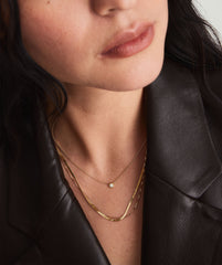 Diamond Necklace on a woman's neck, featuring a 14k solid gold chain and a round cut diamond in a bezel setting.
