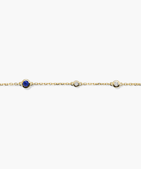 Multi Gemstone Station Bracelet: Handcrafted 14k gold chain adorned with diamonds and a central blue gemstone.