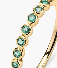 Bezel Emerald Half Eternity Band: 14k solid gold ring with bezel-set emerald gemstones, each gem uniquely characterized by natural inclusions.