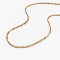 Round Box Chain Necklace on a white surface; a versatile gold chain thatâs perfect for everyday wear, complementing the Round Box Chain Bracelet.