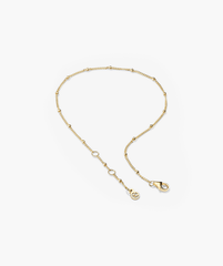 Spheres Bracelet: A minimalist gold chain bracelet with a clasp, featuring small round beads. Versatile for any outfit and occasion.