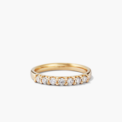 Bold Diamond Half Eternity Ring: a close-up of a 14k gold ring with seven round cut diamonds. Perfect for stacking with the Bold Diamond Eternity Ring.