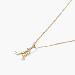 Gold necklace with a cursive letter charm, suitable for layering or personalization with initials, names, or favorite words.