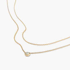 Layered Opal Necklace featuring a gold chain with a natural opal pendant in the center.
