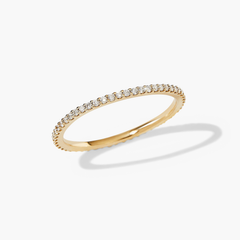 Slim Diamond Eternity Band: Close-up of a gold ring featuring 47-60 hand-set diamonds in open prongs, highlighting its delicate, sparkling design.