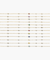 Multi Gemstone Station Bracelet: A grid of gold-chain bracelets, each with bezel-set diamonds and a central birthstone gem, showcasing twelve unique birthstone colors.