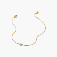 Solo Diamond Bracelet: A close-up of a solid gold bracelet featuring a round cut diamond in a bezel setting. Elegant and timeless design.