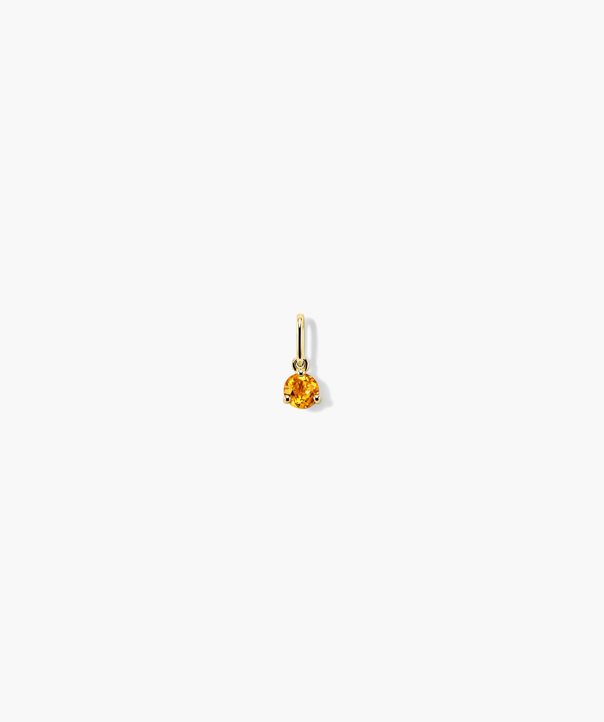 Close-up of a handcrafted 14k gold Birthstone Charm featuring a prominent gemstone, designed as a versatile and elegant earring.