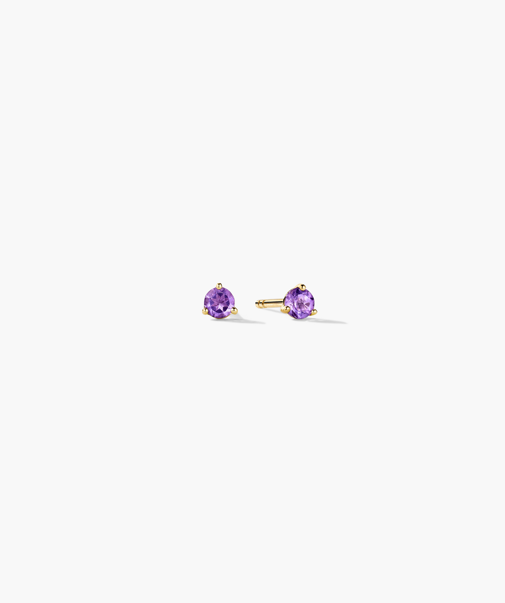 Gemstone Mini Studs feature round, faceted purple gemstones in a three-prong gold setting, showcasing elegant simplicity for everyday wear.