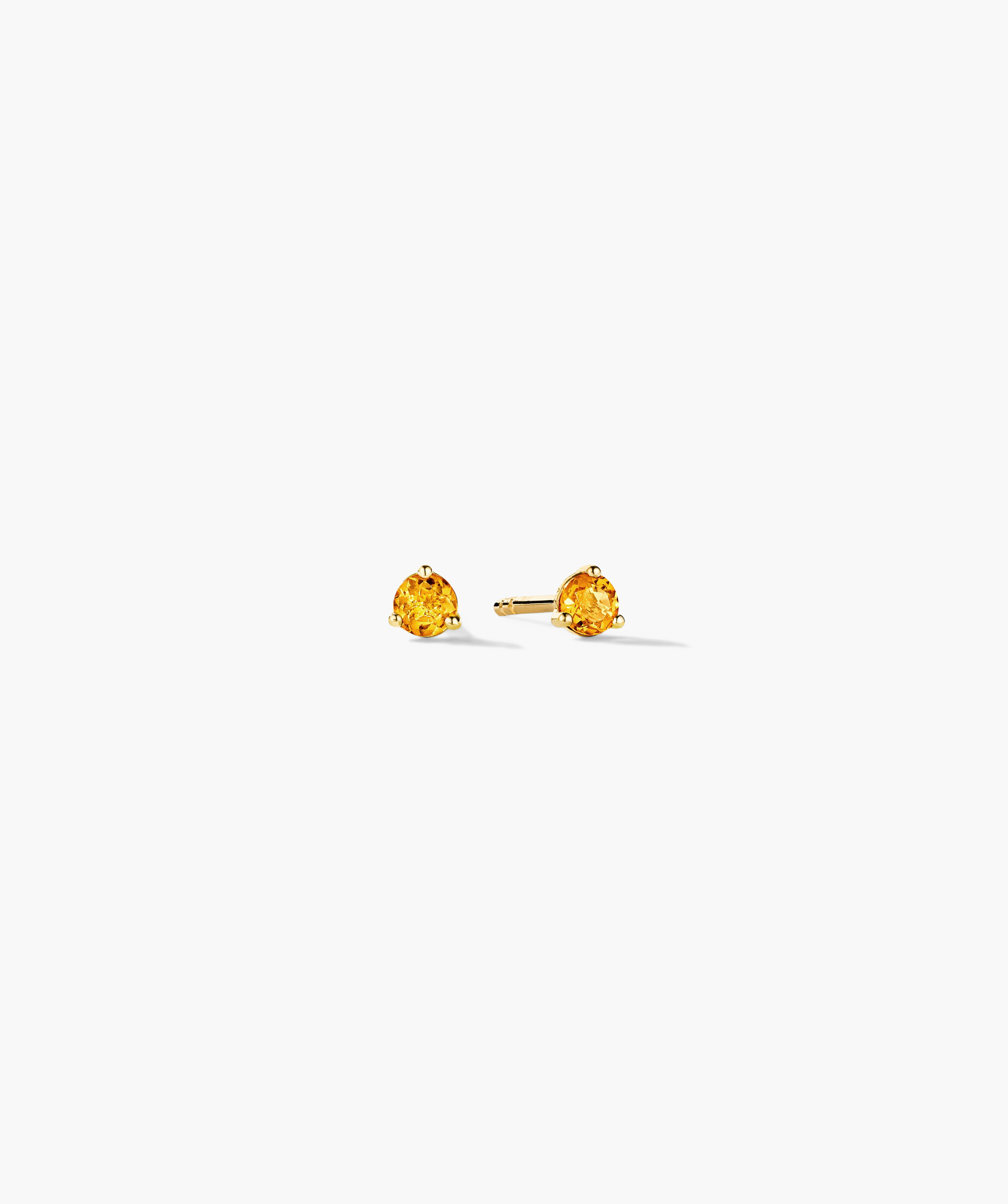 Gemstone Mini Studs featuring round, faceted yellow gemstones in three-prong gold settings, displayed on a white background.