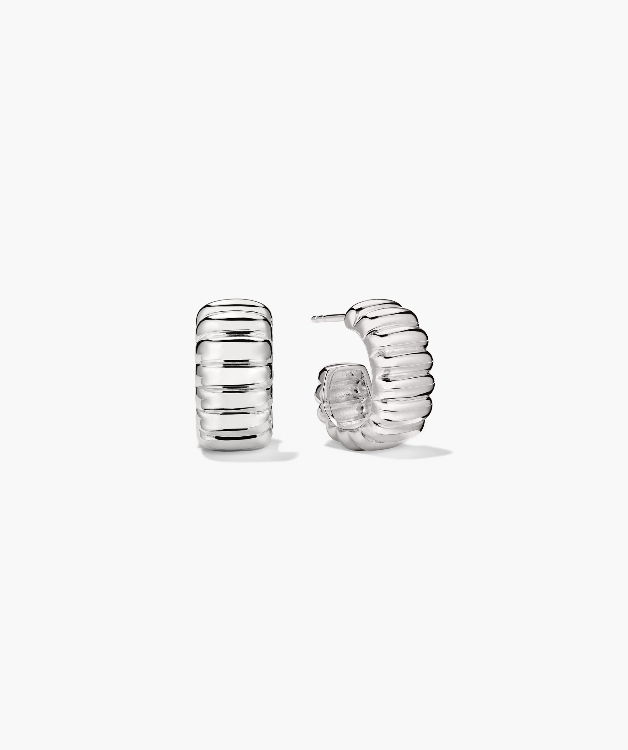 Charlotte Bold Hoops: A pair of silver earrings with a curved design, inspired by French patisserie elegance.