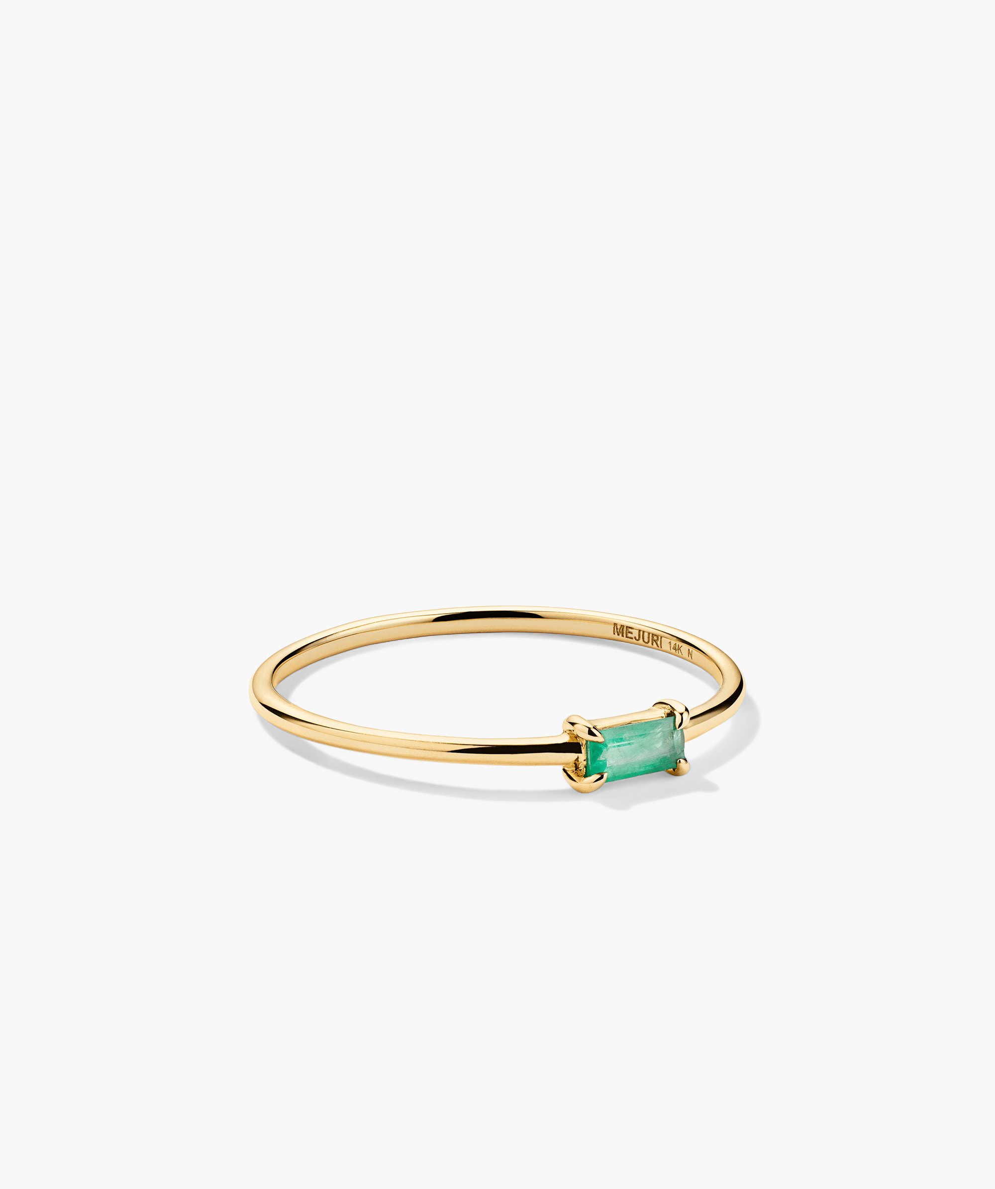 Baguette Stacker Ring: A gold ring featuring a prominent green gemstone, ideal for stacking with other rings for a chic, layered look.