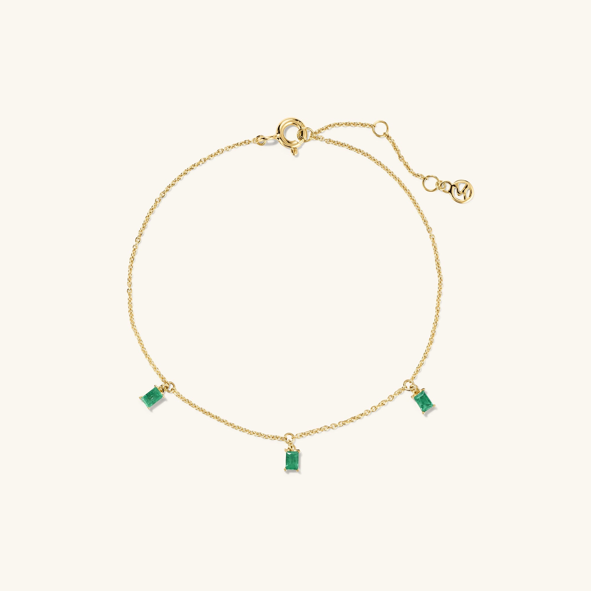 Baguette Gemstone Bracelet: A gold chain bracelet adorned with rectangular green gemstones, perfect for stacking and adding elegance to your accessory collection.