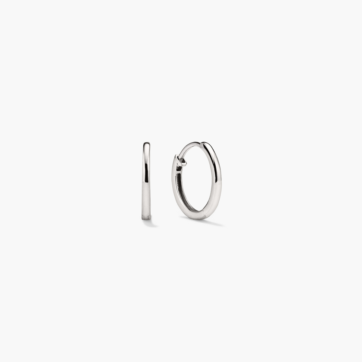 Easy Huggie Hoops: Close-up of a pair of handcrafted, hollowed 14k gold earrings with a secure clicker closure, ideal for everyday wear.