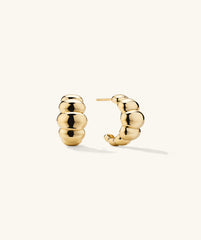 Puffy Charlotte Hoops: a pair of bold, curved gold earrings with a shiny finish, designed to make a statement in the Charlotte Collection.