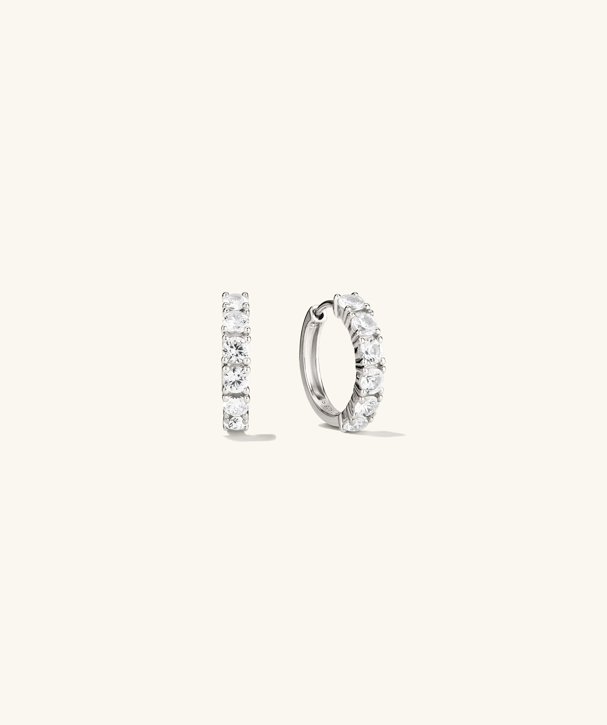 Lab Grown Sapphire Small Hoops, intricately designed earrings, portrayed in a detailed sketch, emphasizing their shiny, slightly larger size than typical huggies.