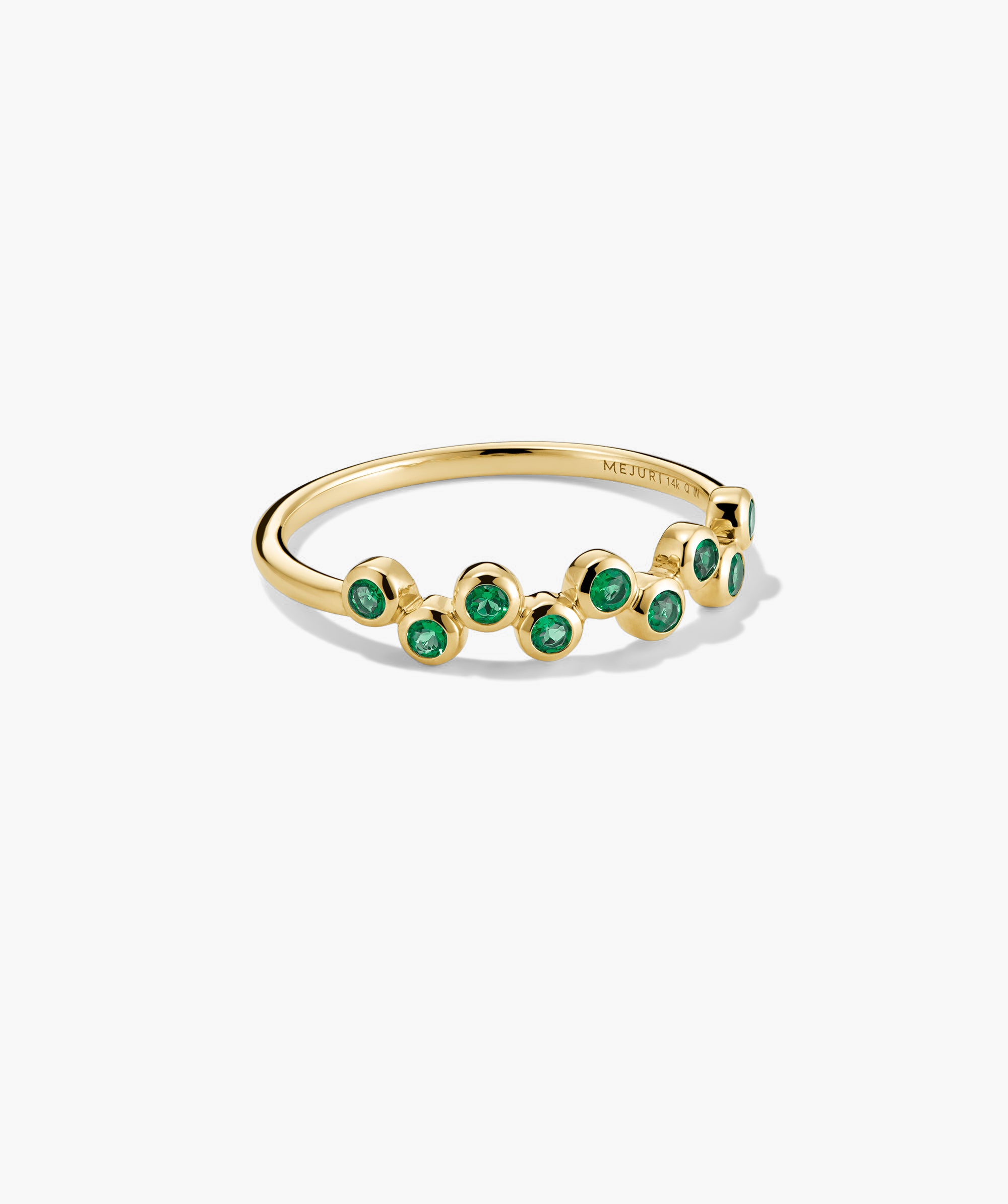 Ziggy Ring featuring bezel-set lab-grown green gemstones in a zig-zag pattern on a gold band, designed for stacking and light-catching sparkle.