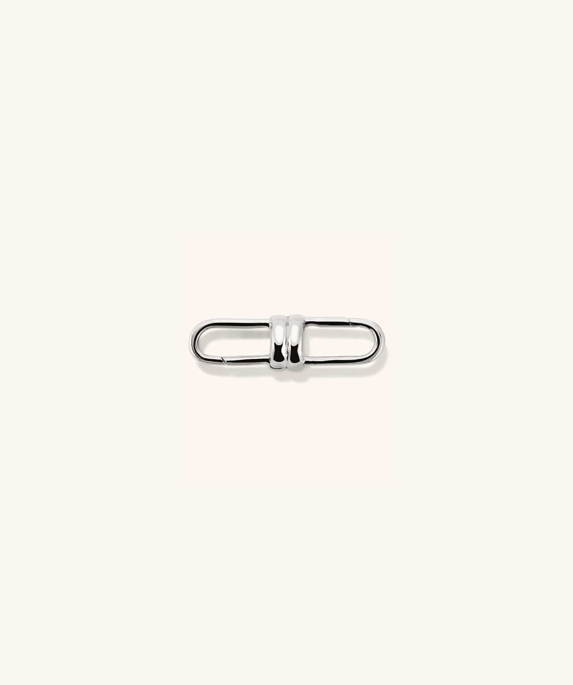 Mejuri Custom Chain Enhancer: A close-up of a silver metal clasp designed to attach to various chains for added versatility and style.