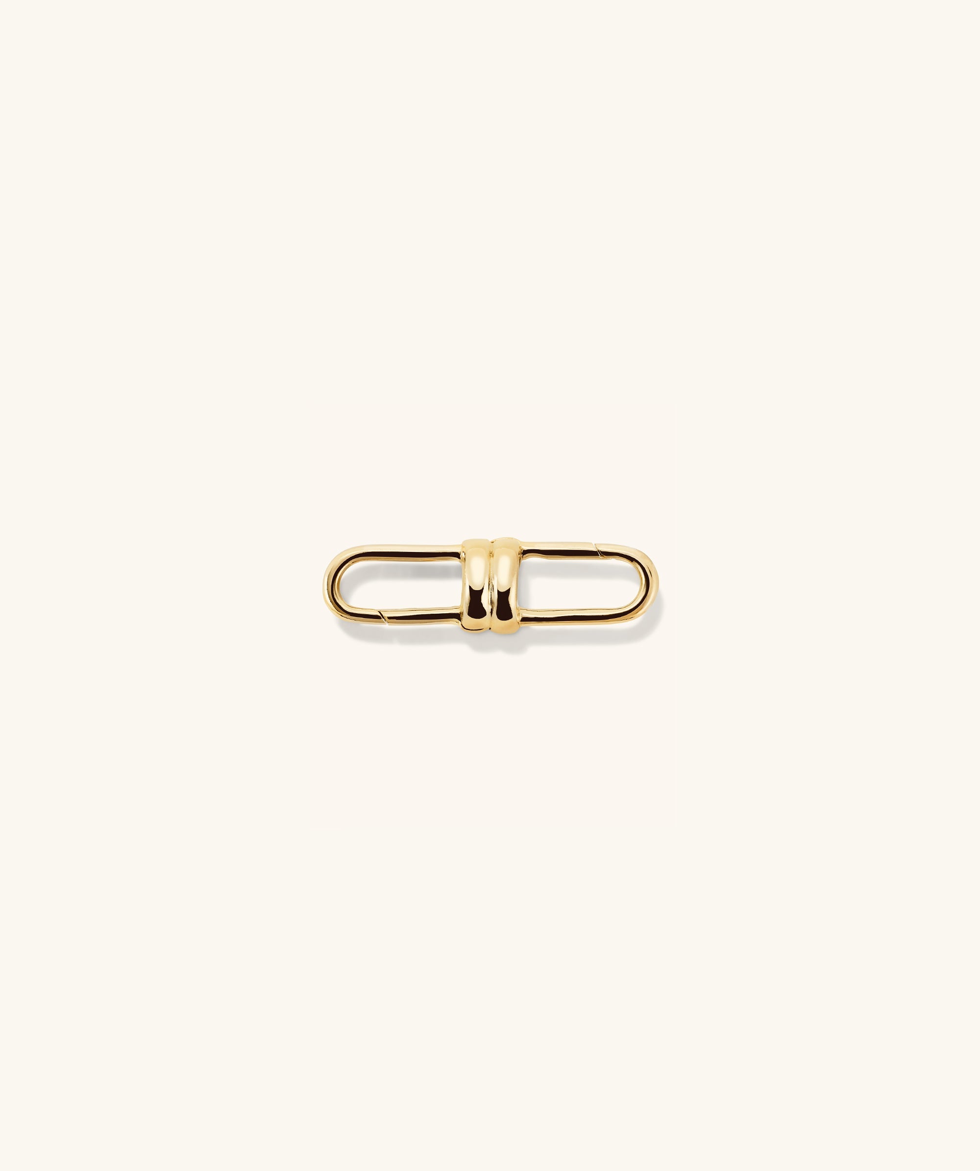 Mejuri Custom Chain Enhancer featuring a gold metal clasp with a black center, and a gold chain with several rings.