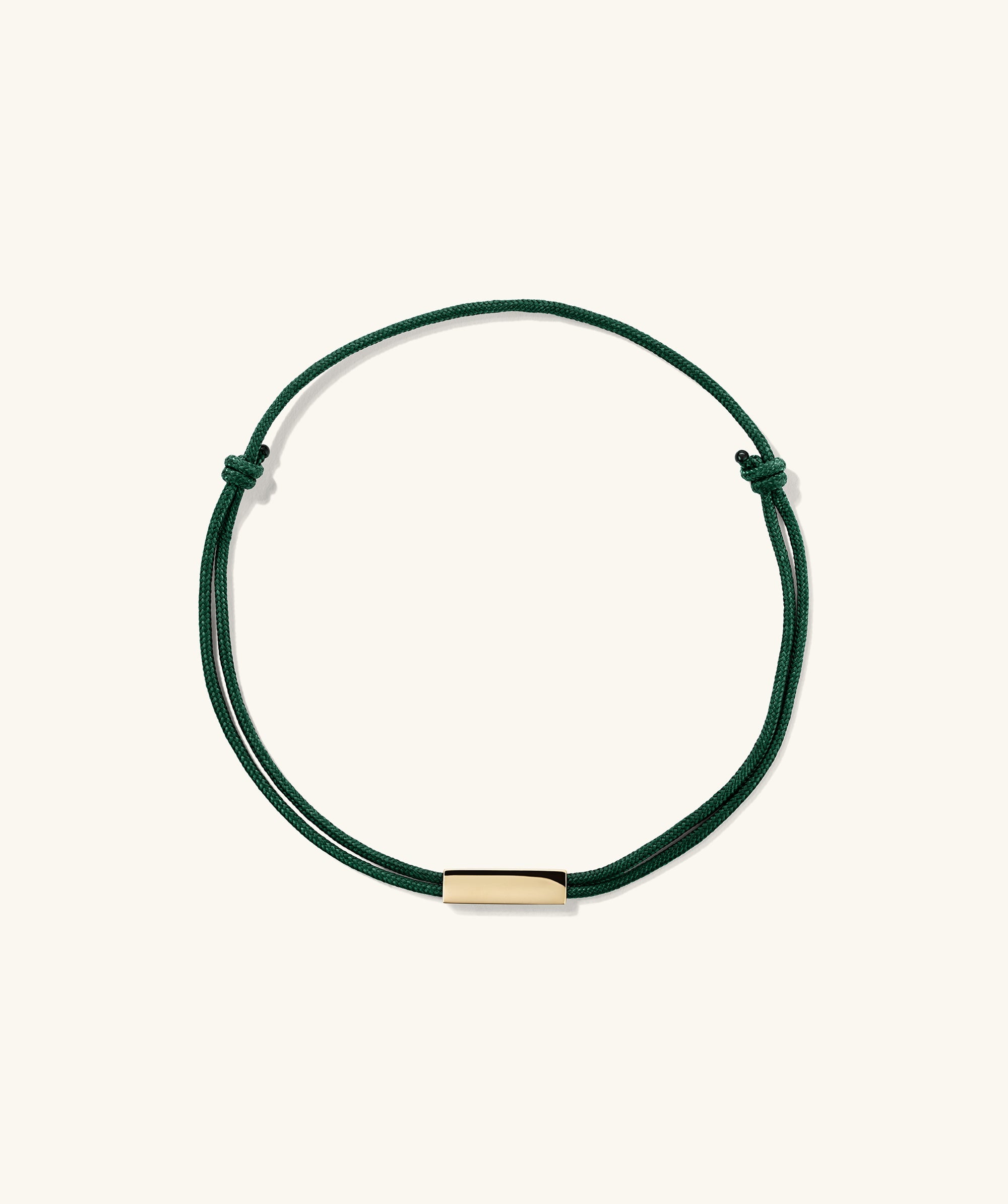 Bar Cord Bracelet featuring a green string with a gold bar, ideal for adding a signature touch to your fashion accessories.