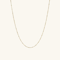 Spheres Chain Necklace: A minimalistic gold chain featuring a small diamond pendant, perfect for any occasion, making a subtle yet significant fashion statement.