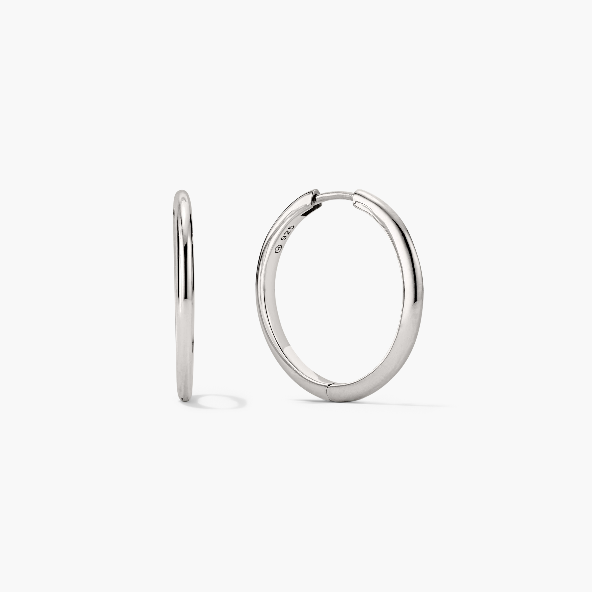 Tube Large Hoops: A pair of modern, lightweight silver hoop earrings with a clicker closure, designed for comfort and security.