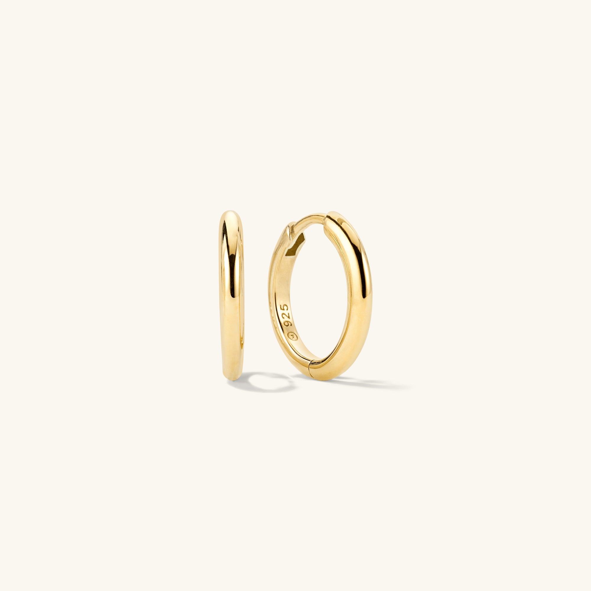 Tube Medium Hoops: A pair of gold hoop earrings with a modern tube design and a secure clicker closure for comfort.