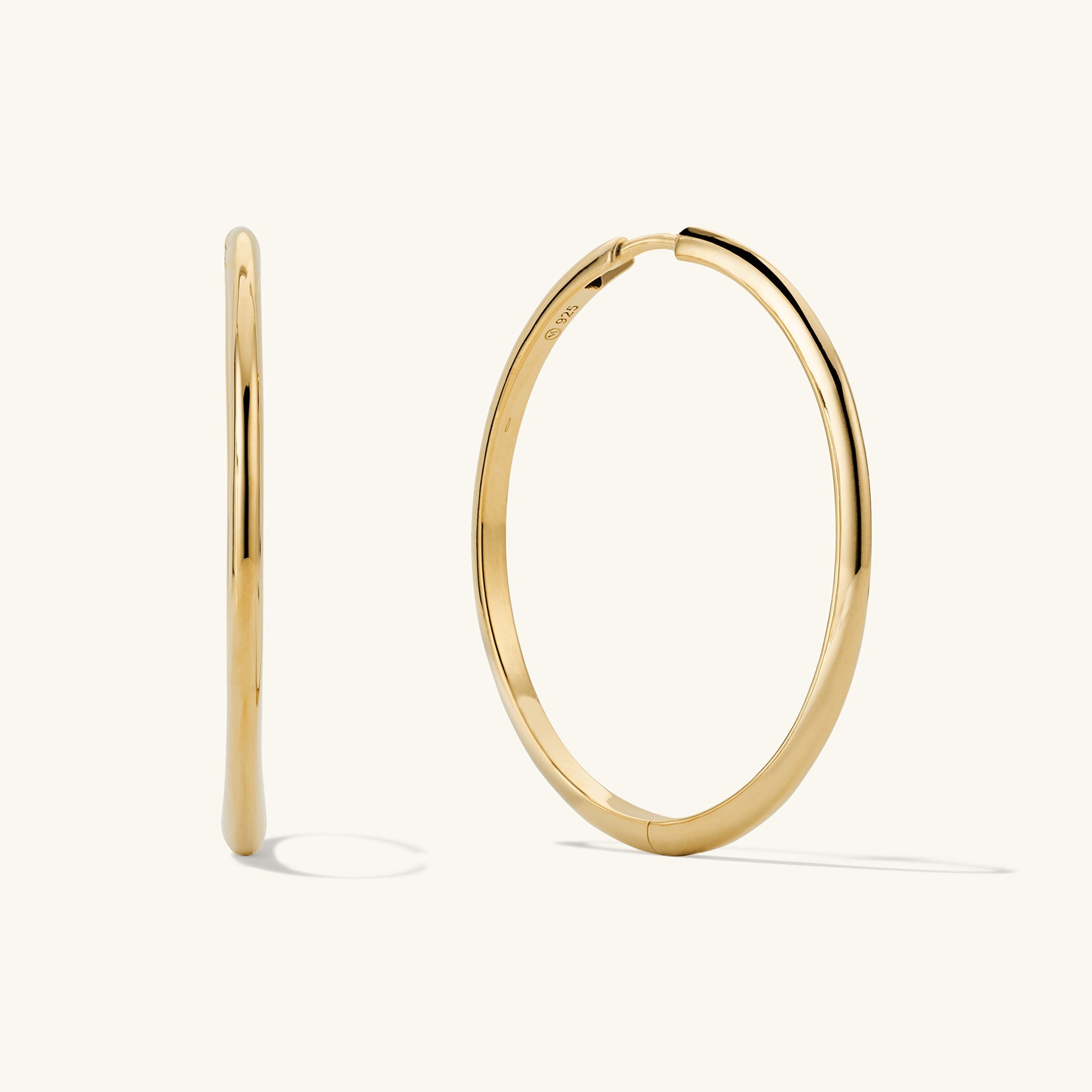 Tube Oversized Hoops: Modern, lightweight gold hoop earrings with a clicker closure for comfort and security, perfect for everyday wear.
