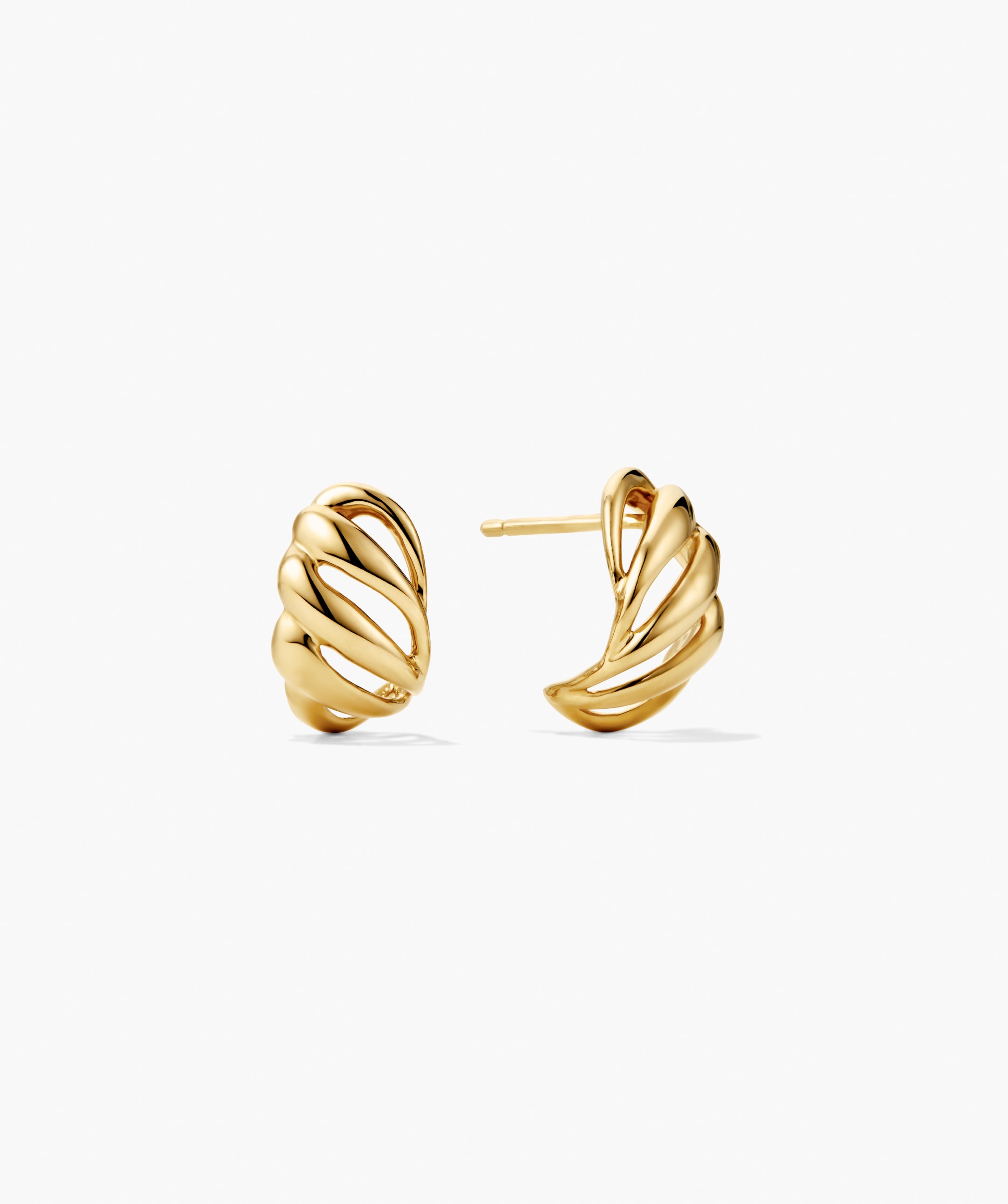 Bold Open DÃ´me Huggies feature sculptural gold studs with twisting, ribbon-like forms and open spaces, creating a light, airy, and asymmetrical design.