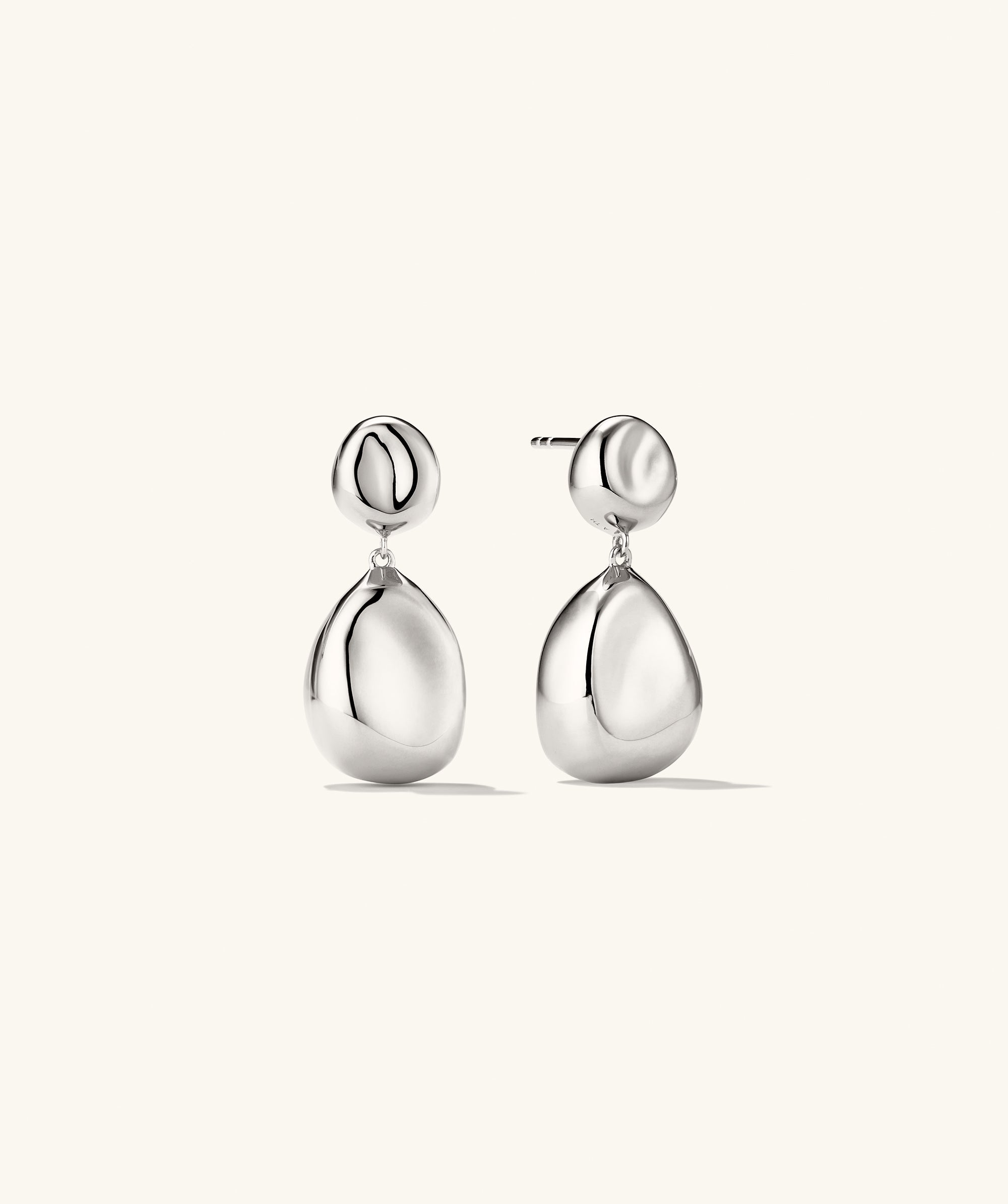 Organic DÃ´me Pebble Earrings featuring a pair of elegant, silver drop earrings with a refined, natural design, perfect for versatile fashion statements.