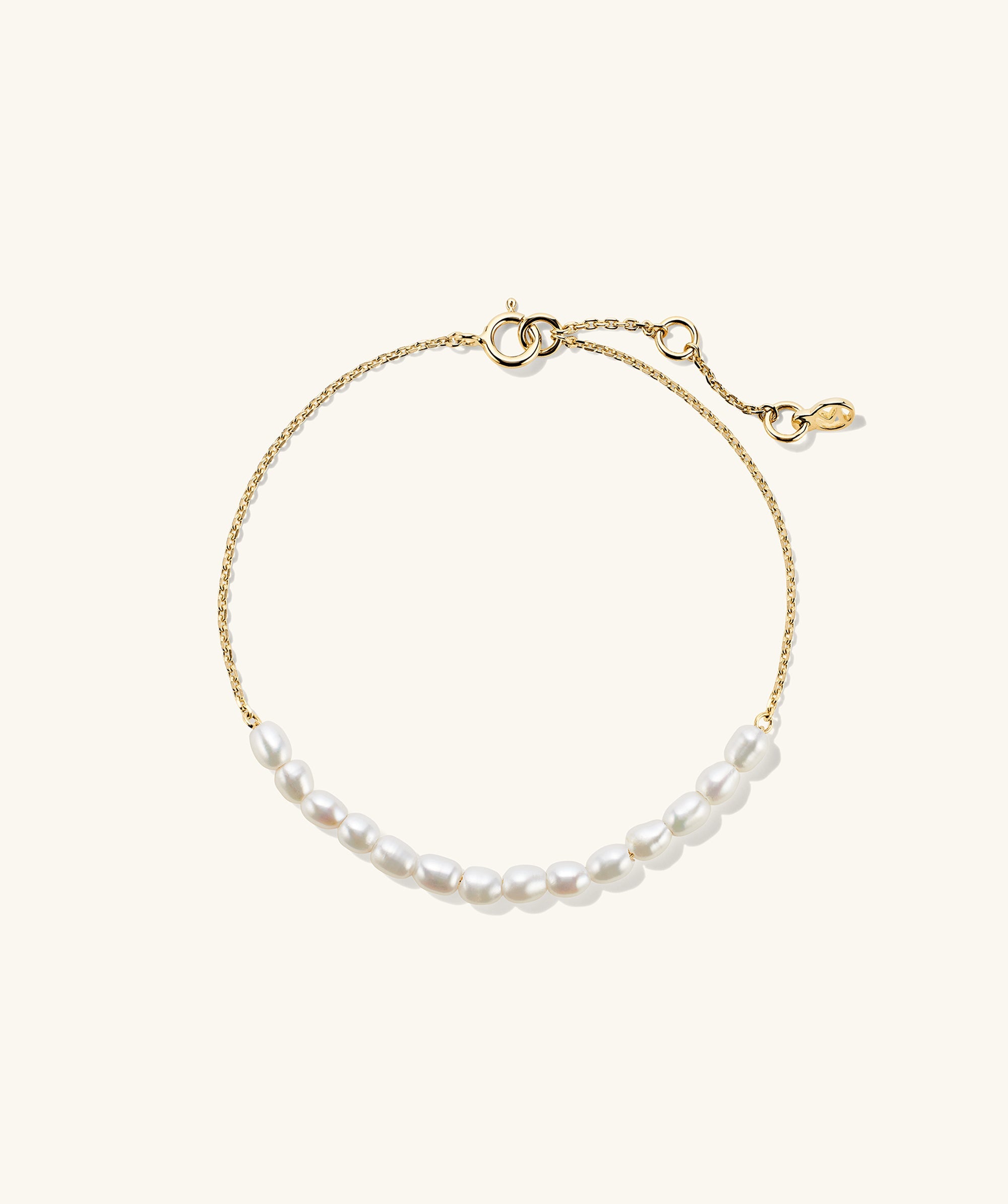 Tiny Pearl Bracelet featuring a delicate gold chain adorned with small, evenly spaced pearls, showcasing a refined and elegant design for a sophisticated look.