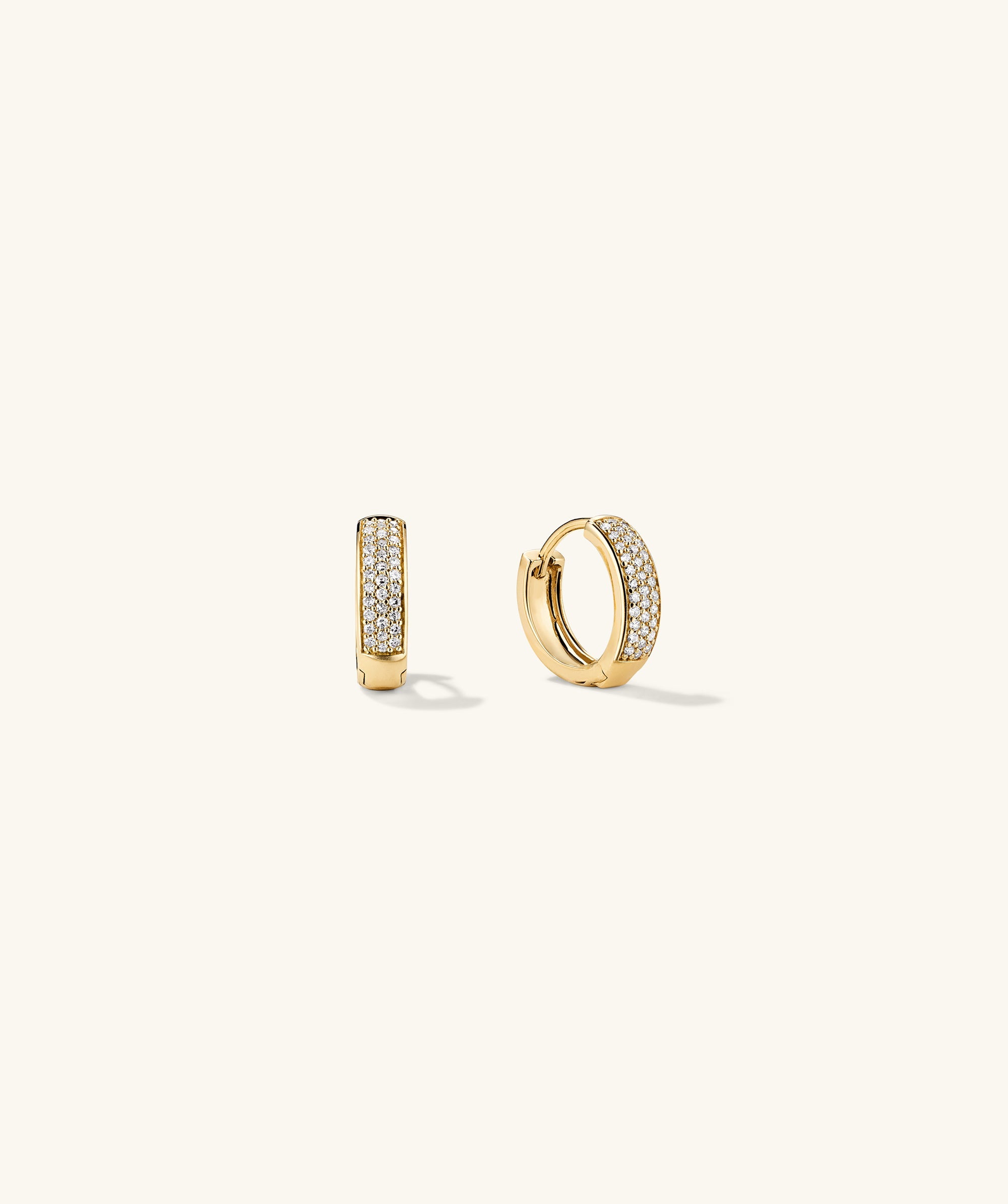 Bold PavÃ© Diamond Huggie Hoops: A pair of 14k gold hoop earrings adorned with responsibly sourced diamonds, handcrafted for an elegant, eye-catching look.