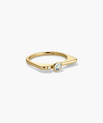 Puzzle Stacking Ring: A gold-tone ring with a teardrop blue gemstone and tiny white stone on a slim band, designed for customizable stacking.