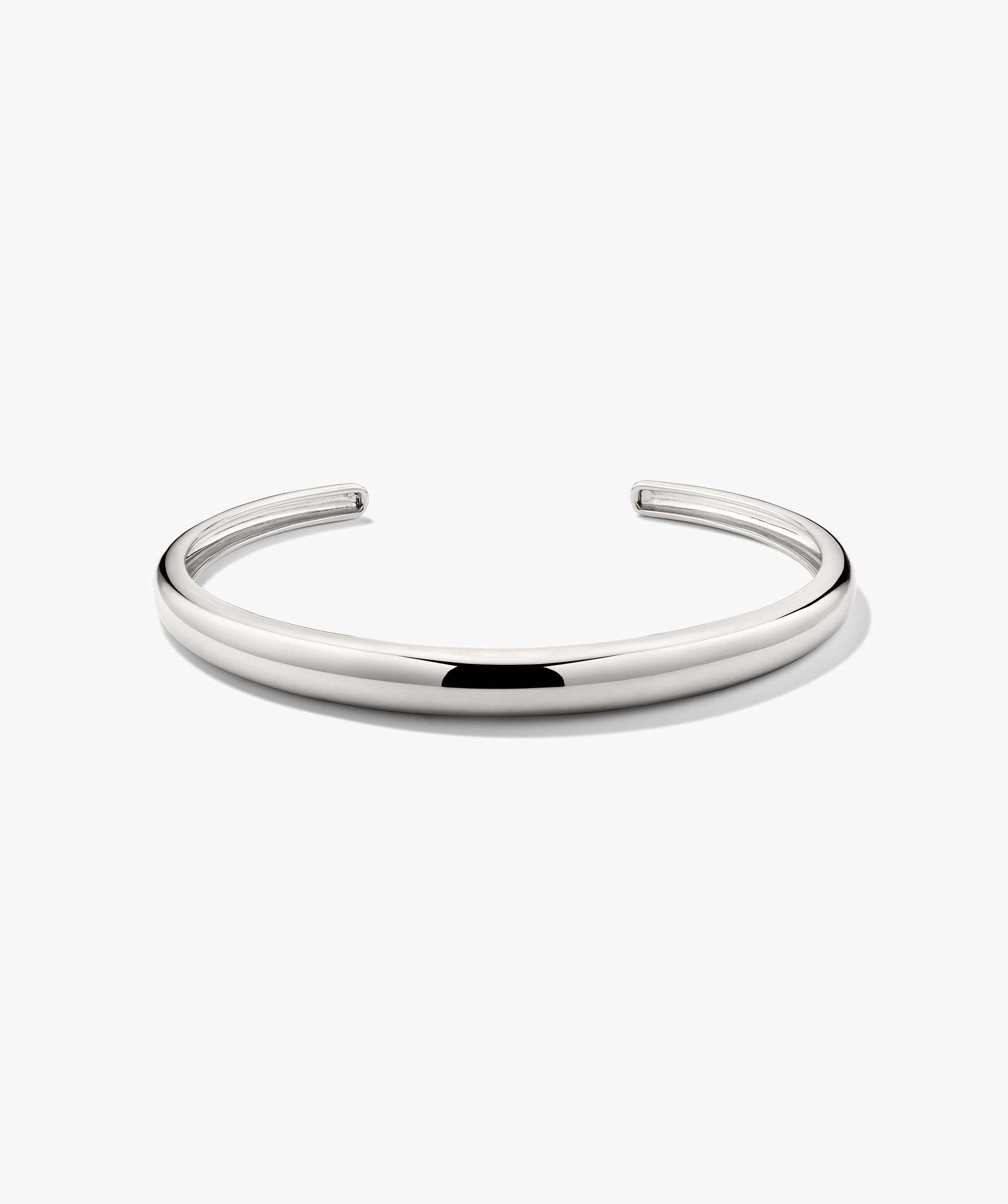 DÃ´me Cuff Bracelet: A polished silver-metal, open-ended bangle, reminiscent of a ray of sunshine, elegantly displayed on a plain white background.