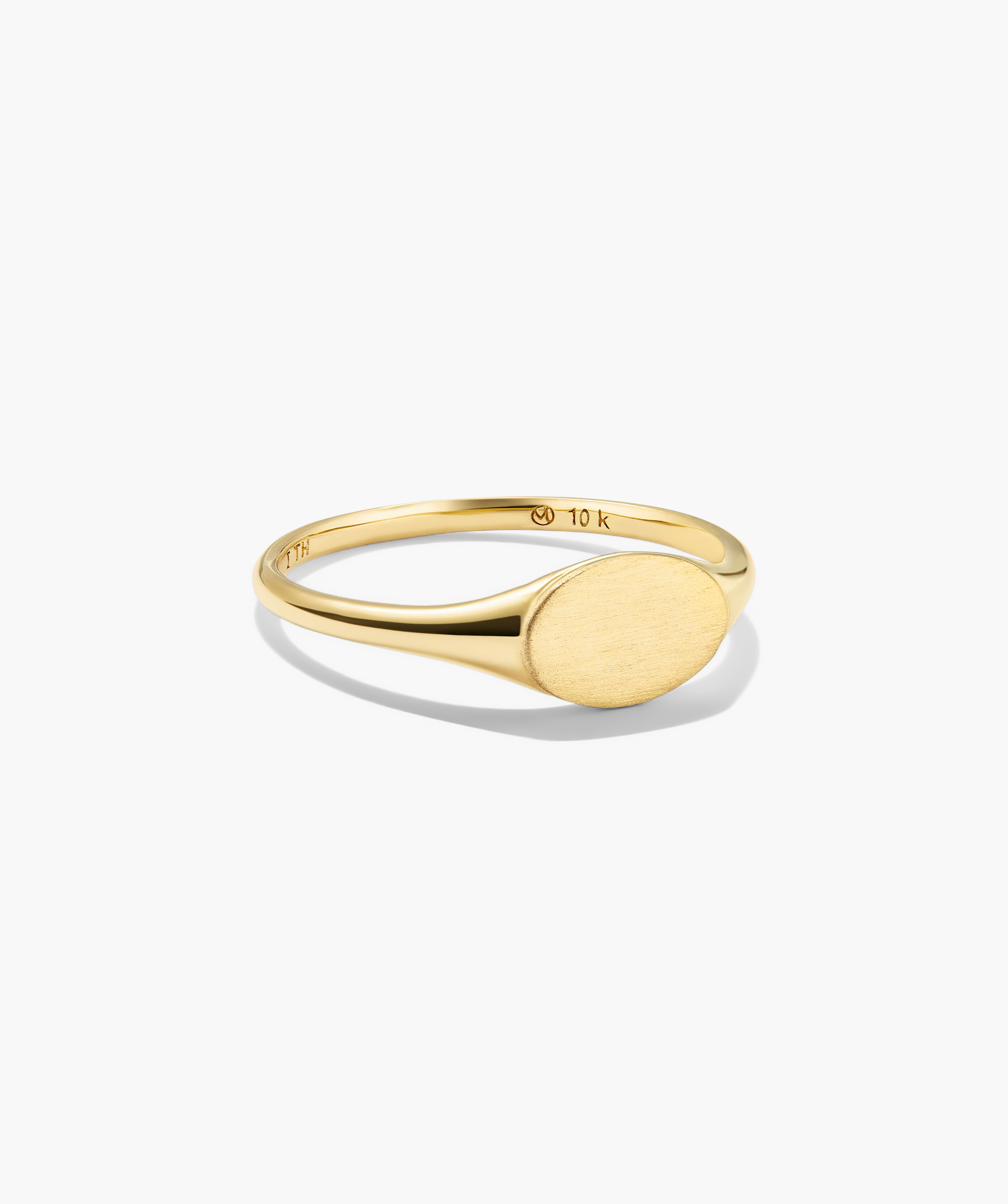 Signet Ring: A slender, 10-karat yellow-gold ring with an unengraved, brushed oval face, offering a modern twist on a classic design.