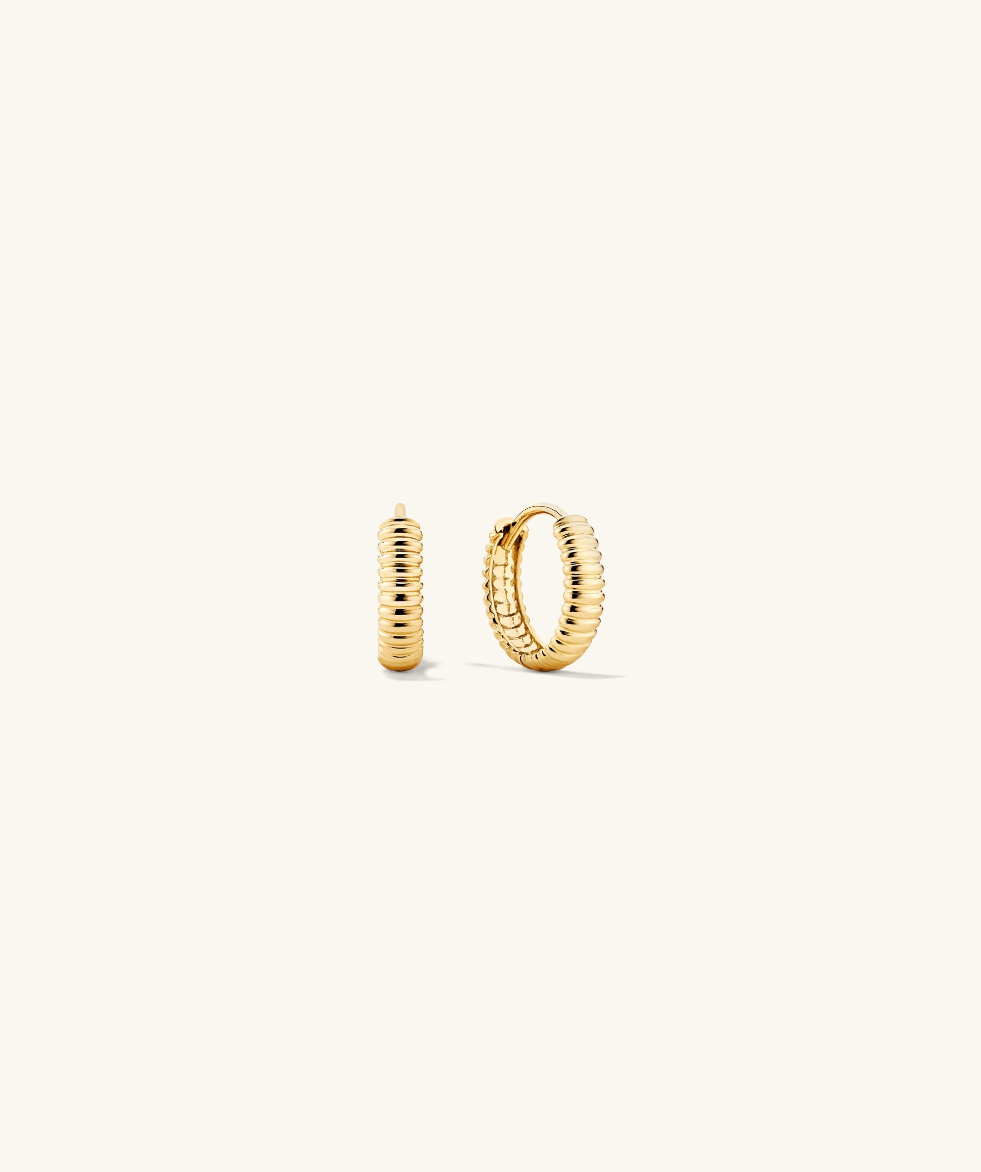 Bold Micro Charlotte Huggie Hoop Salmon Gold earrings with a curved hoop design, showcasing intricate craftsmanship and elegant style.