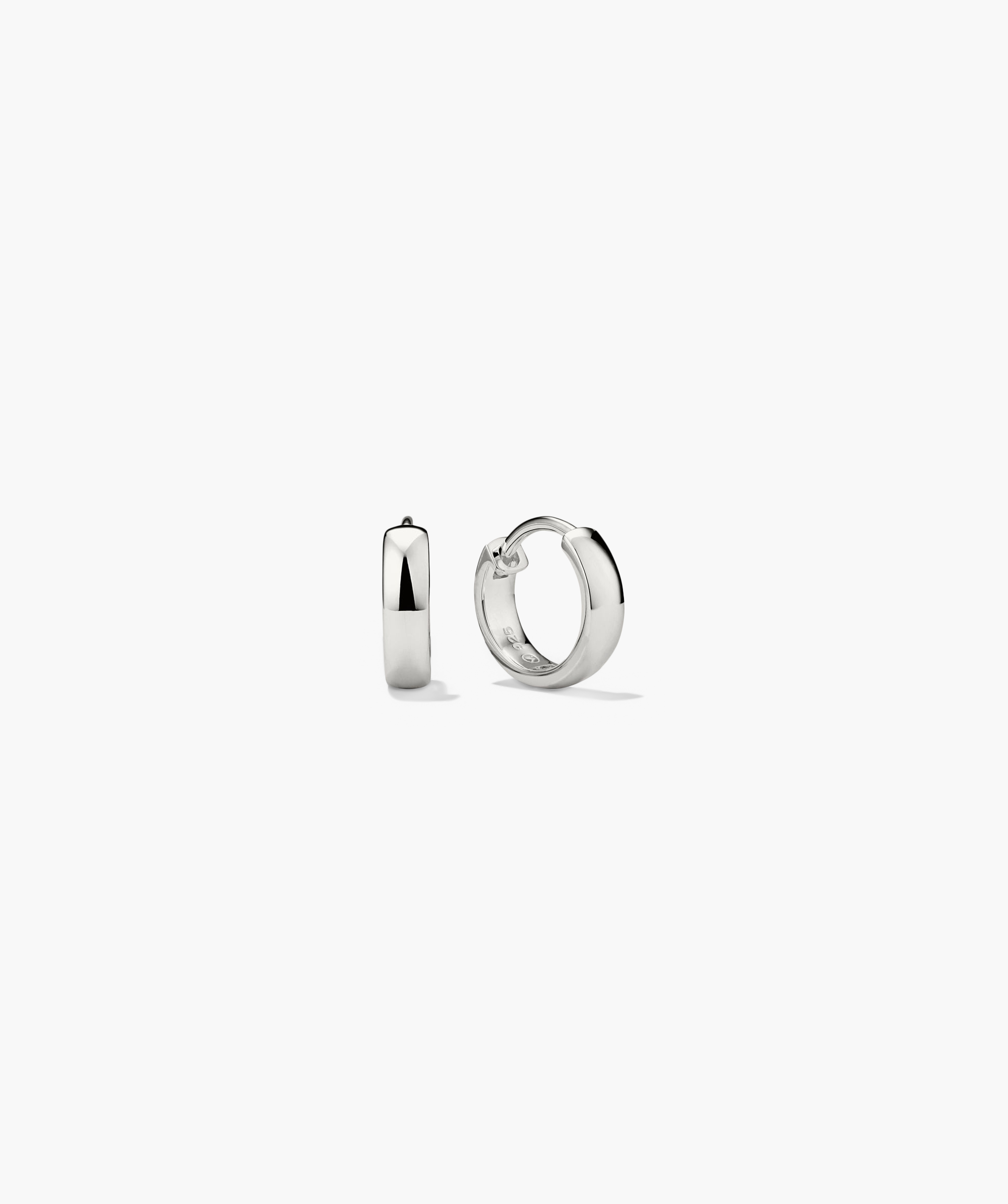 Bold Huggie Hoops: Close-up of a pair of silver hoop earrings, known for their outfit-elevating and mood-boosting qualities.