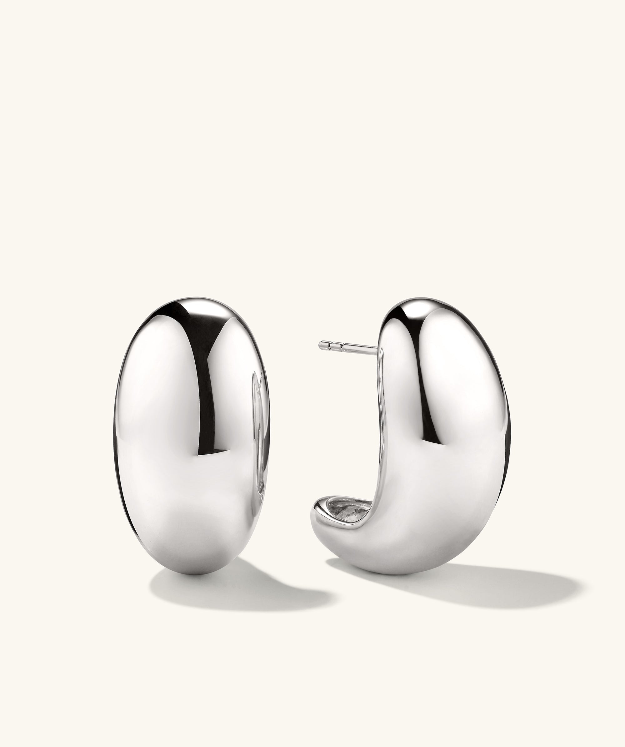 Mega DÃ´me Earrings: A pair of large, shiny silver earrings designed with a bold, puffed shape, part of the DÃ´me collection, commanding attention effortlessly.