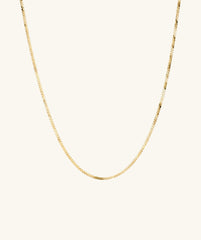 Serpentine Chain Necklace: A sleek gold chain, minimal yet striking, perfect for any occasion, shown on a white background.