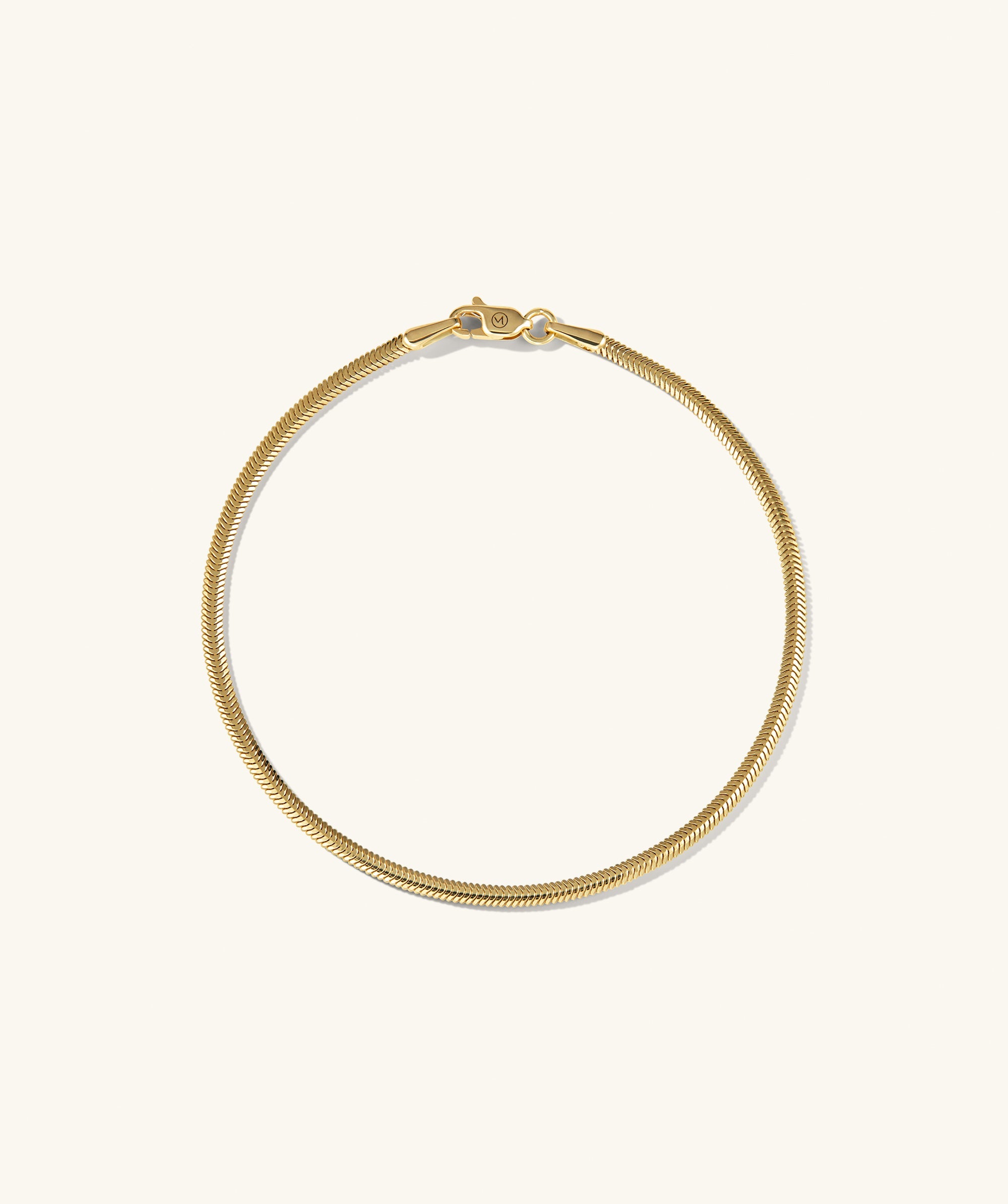 Cobra Bracelet: A gold chain with a clasp, showcasing intricate links, designed as a fashionable body jewelry piece.