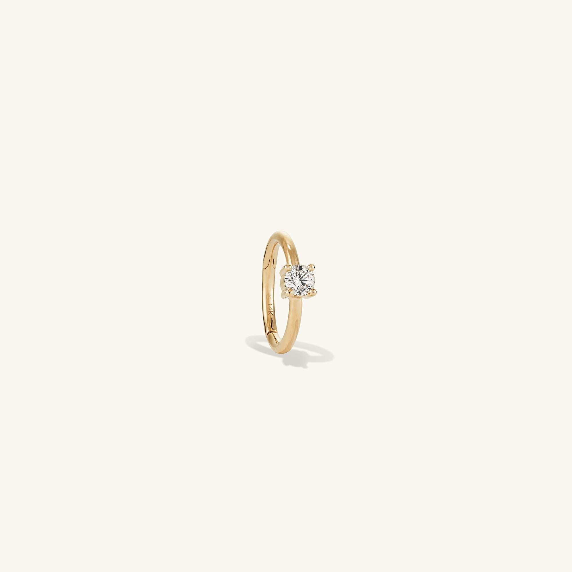 Cartilage Solo Diamond Mini Hoop: a close-up of a 14k solid gold hoop with a hinge clasp, set with a single responsibly sourced diamond, designed for helix wear.